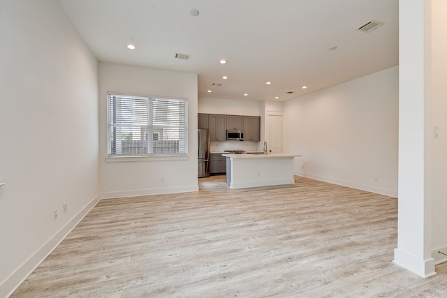 2718 Oakwood Crest Ln, Houston, TX 77018 - kitchen with light wood-type flooring, visible vents, light countertops, appliances with stainless steel finishes, and open floor plan