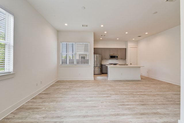 2718 Oakwood Crest Ln, Houston, TX 77018 - unfurnished living room with a healthy amount of sunlight, recessed lighting, and light wood-style floors