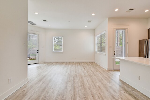 2718 Oakwood Crest Ln, Houston, TX 77018 - unfurnished living room featuring visible vents, baseboards, and light wood-type flooring