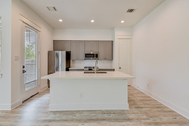 2718 Oakwood Crest Ln, Houston, TX 77018 - kitchen with stainless steel appliances, gray cabinetry, visible vents, and a center island with sink