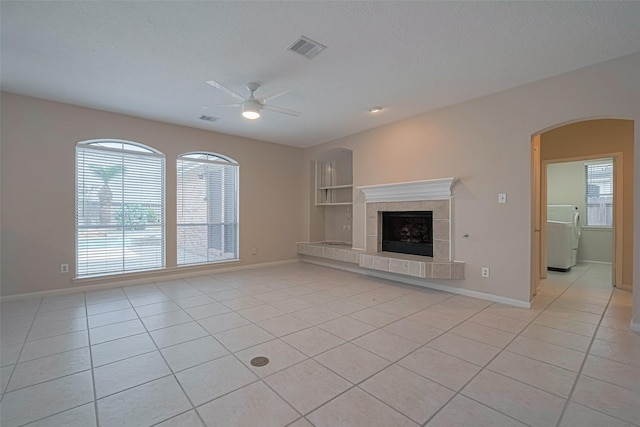 4530 Lakeside Meadow Dr, Missouri City, TX 77459 - unfurnished living room featuring a ceiling fan, arched walkways, light tile patterned flooring, and healthy amount of natural light