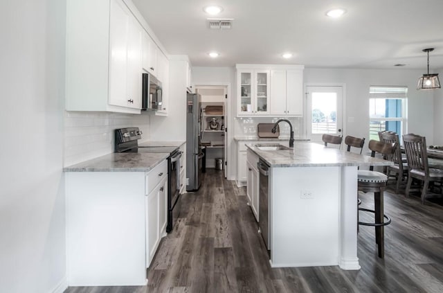 418 E St, East Bernard, TX 77435 - kitchen featuring an island with sink, a breakfast bar, visible vents, a sink, and appliances with stainless steel finishes