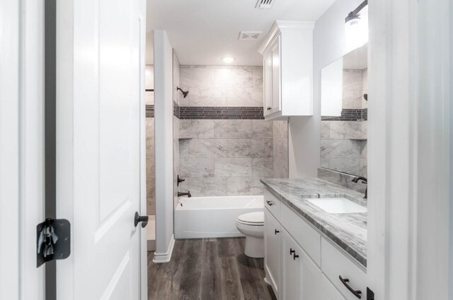 418 E St, East Bernard, TX 77435 - bathroom with wood finished floors, visible vents, toilet, vanity, and shower / bathing tub combination