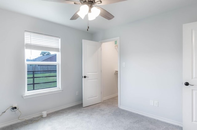 418 E St, East Bernard, TX 77435 - unfurnished bedroom with light colored carpet, baseboards, and a ceiling fan