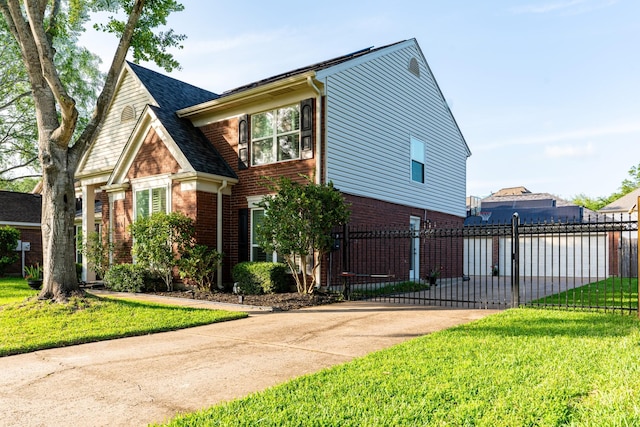 view of front facade with brick siding, fence, driveway, and a front yard