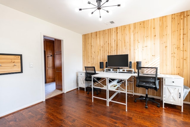office area with visible vents, baseboards, an inviting chandelier, wood finished floors, and wooden walls