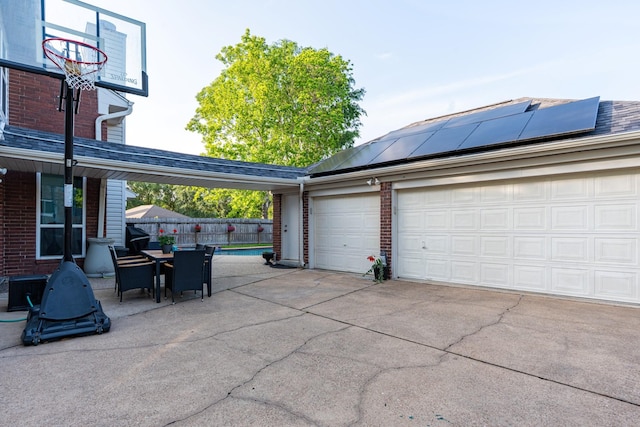 garage with concrete driveway and fence