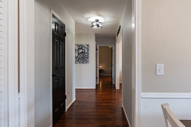 corridor featuring dark wood-style flooring