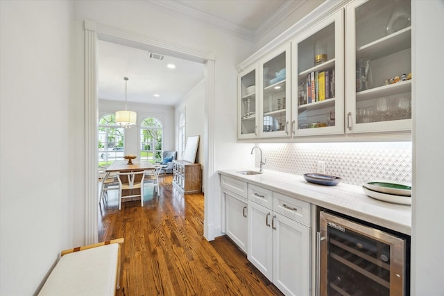 bar with wine cooler, visible vents, a sink, decorative backsplash, and dark wood-style flooring
