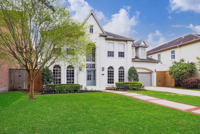 french country style house featuring fence, a front lawn, a garage, and concrete driveway