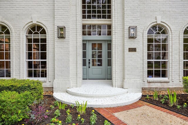 view of exterior entry featuring brick siding