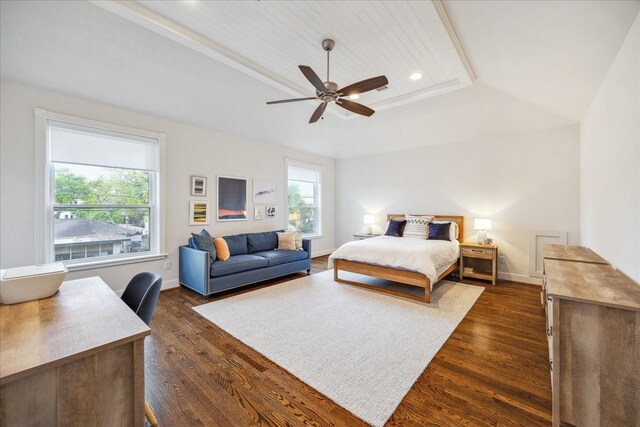bedroom with ceiling fan, dark wood-style flooring, a tray ceiling, and multiple windows