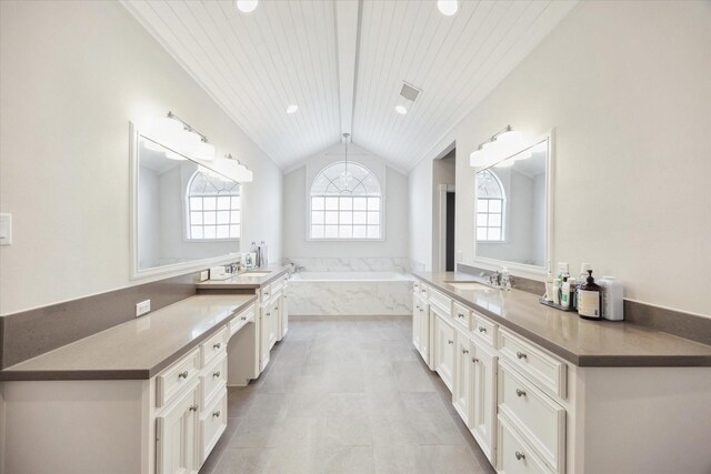 bathroom featuring recessed lighting, a bath, vaulted ceiling, and vanity