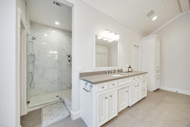 bathroom with a tile shower, tile patterned floors, visible vents, vanity, and baseboards
