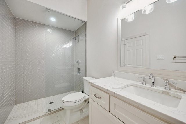 full bath featuring tile patterned flooring, vanity, toilet, and tiled shower