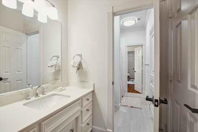 bathroom featuring baseboards, crown molding, vanity, and visible vents