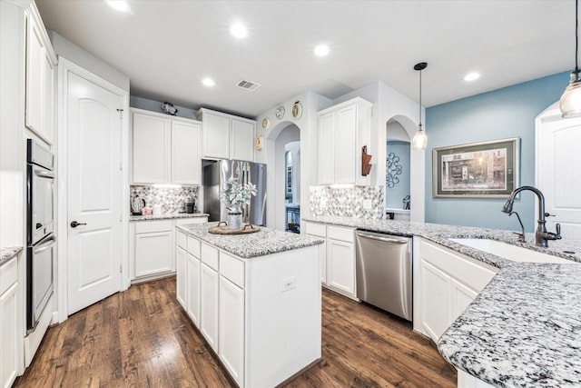 2807 Merlin Ln, Pearland, TX 77581 - kitchen with a sink, arched walkways, stainless steel appliances, backsplash, and visible vents