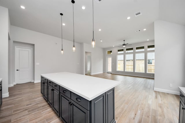 kitchen with visible vents, baseboards, ceiling fan, light countertops, and light wood-style floors
