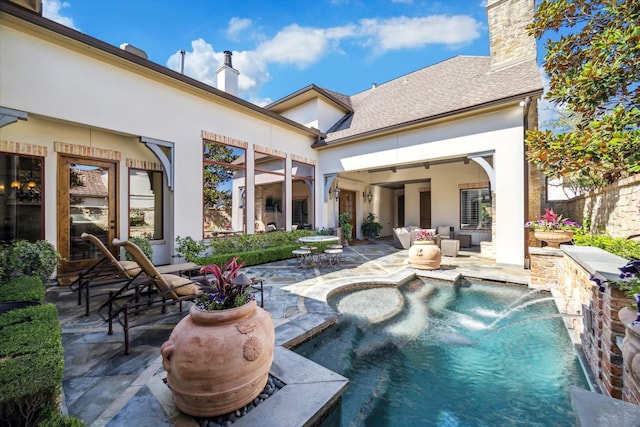 back of house featuring a patio, an outdoor pool, stucco siding, and a chimney