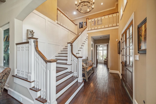 entryway featuring baseboards, ornamental molding, hardwood / wood-style flooring, and stairway