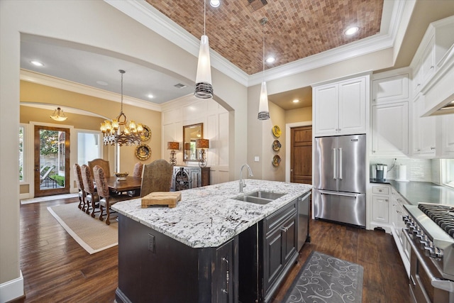 kitchen with dark wood-style flooring, light stone countertops, arched walkways, a sink, and stainless steel appliances