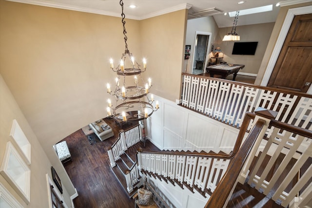stairway with a chandelier, recessed lighting, wood finished floors, visible vents, and ornamental molding