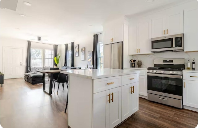 2205 Rosewood St, Houston, TX 77004 - kitchen with stainless steel appliances, light countertops, white cabinets, dark wood-style floors, and a kitchen island