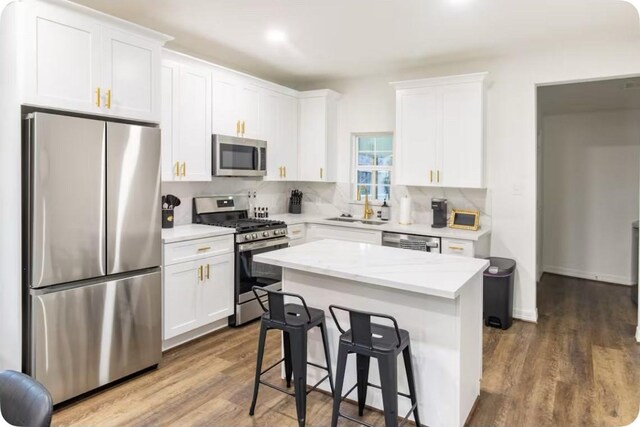 2205 Rosewood St, Houston, TX 77004 - kitchen with white cabinets, appliances with stainless steel finishes, wood finished floors, and a sink