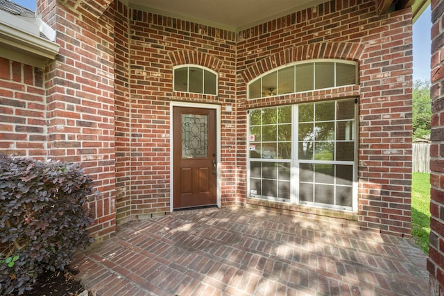 view of exterior entry with brick siding