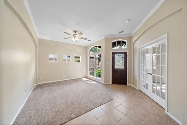 tiled entryway featuring crown molding, a ceiling fan, visible vents, baseboards, and french doors