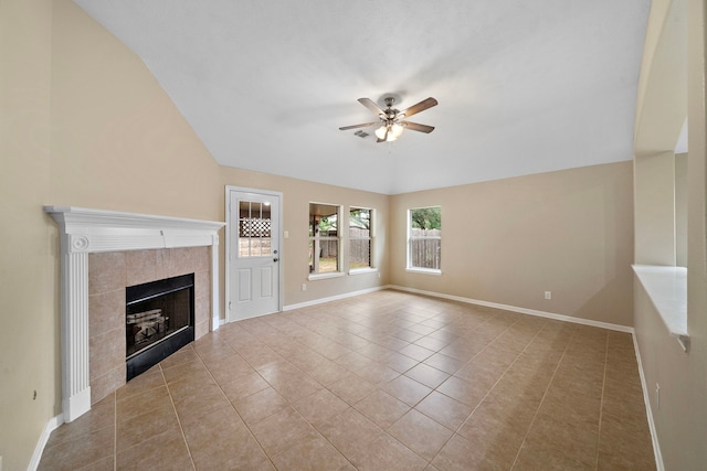 unfurnished living room featuring a fireplace, a ceiling fan, vaulted ceiling, baseboards, and tile patterned flooring