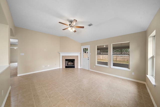 unfurnished living room with light tile patterned floors, visible vents, ceiling fan, a tile fireplace, and vaulted ceiling