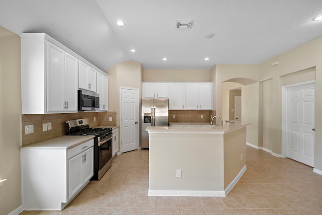 kitchen featuring light tile patterned floors, visible vents, white cabinetry, arched walkways, and appliances with stainless steel finishes