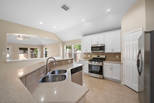 kitchen with decorative backsplash, stainless steel appliances, a sink, white cabinetry, and visible vents