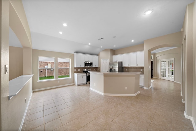 kitchen featuring appliances with stainless steel finishes, light tile patterned floors, and decorative backsplash