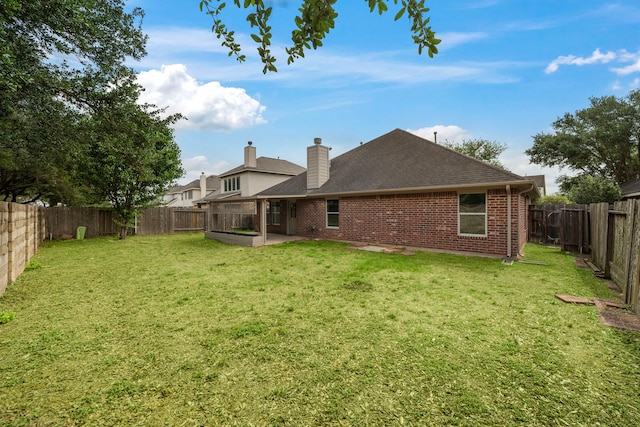 back of house featuring a patio, roof with shingles, a fenced backyard, and brick siding
