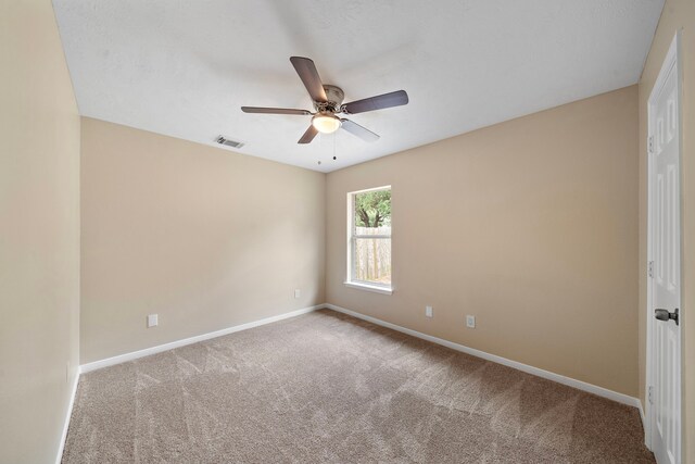 spare room with baseboards, visible vents, a ceiling fan, and carpet floors