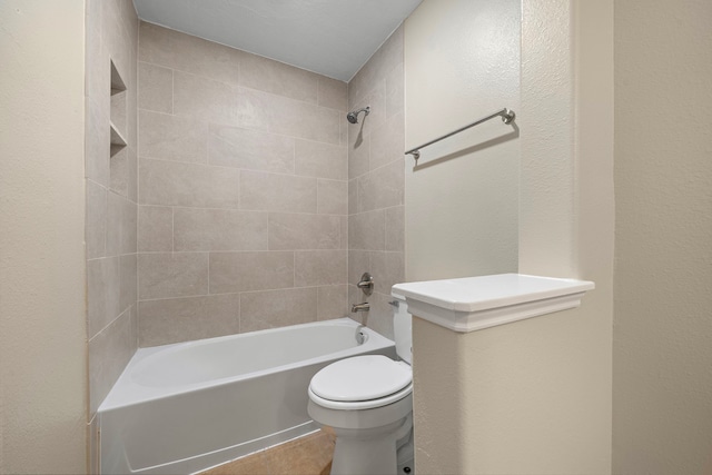full bathroom featuring washtub / shower combination, toilet, and tile patterned flooring