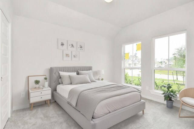 bedroom with light carpet, vaulted ceiling, and baseboards