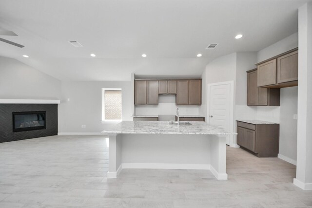 kitchen with baseboards, visible vents, a kitchen island with sink, and recessed lighting