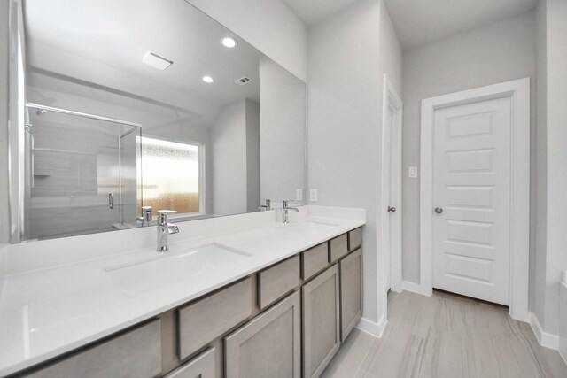 full bathroom with recessed lighting, a sink, double vanity, and a stall shower