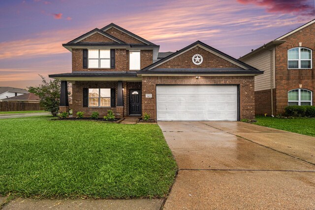 view of front of house with brick siding, a yard, an attached garage, and concrete driveway