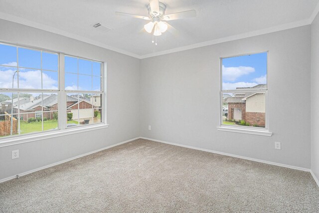 spare room featuring visible vents, ornamental molding, carpet floors, baseboards, and ceiling fan