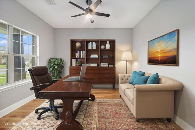 office space featuring plenty of natural light, light wood finished floors, baseboards, and ceiling fan