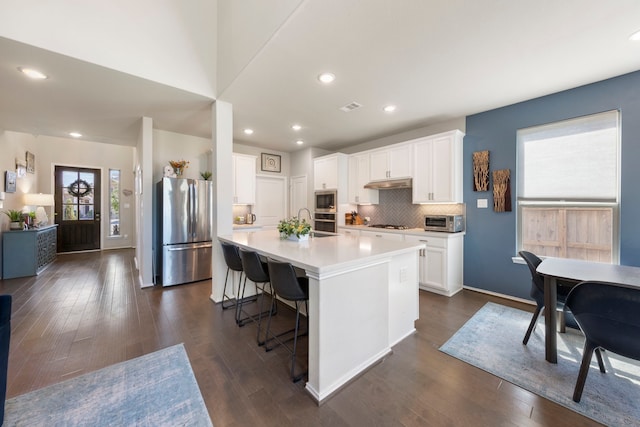 32055 August Woods Way, Conroe, TX 77385 - kitchen featuring a kitchen island with sink, stainless steel appliances, dark wood-style floors, and light countertops