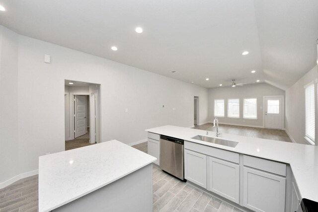 kitchen featuring a sink, dishwasher, light countertops, lofted ceiling, and recessed lighting