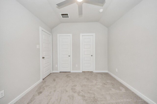unfurnished bedroom with lofted ceiling, visible vents, a ceiling fan, baseboards, and carpet flooring