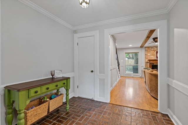 interior space featuring baseboards, crown molding, and brick floor