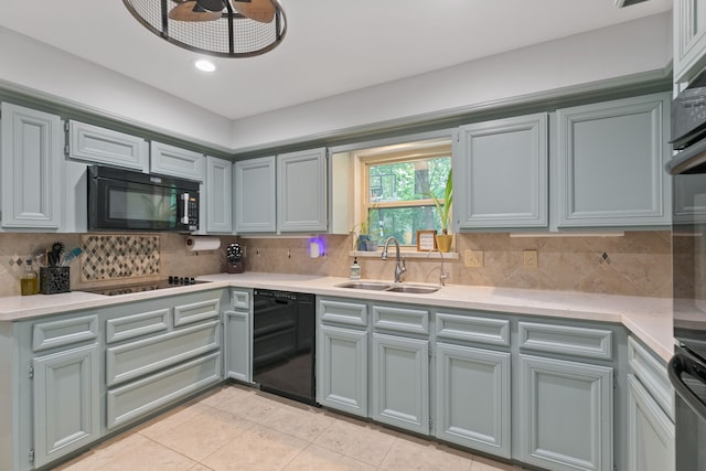 kitchen with a sink, tasteful backsplash, light tile patterned flooring, light countertops, and black appliances