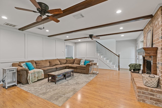 11731 Glenway Dr, Houston, TX 77070 - living room featuring a decorative wall, ceiling fan, beamed ceiling, stairway, and light wood-style floors